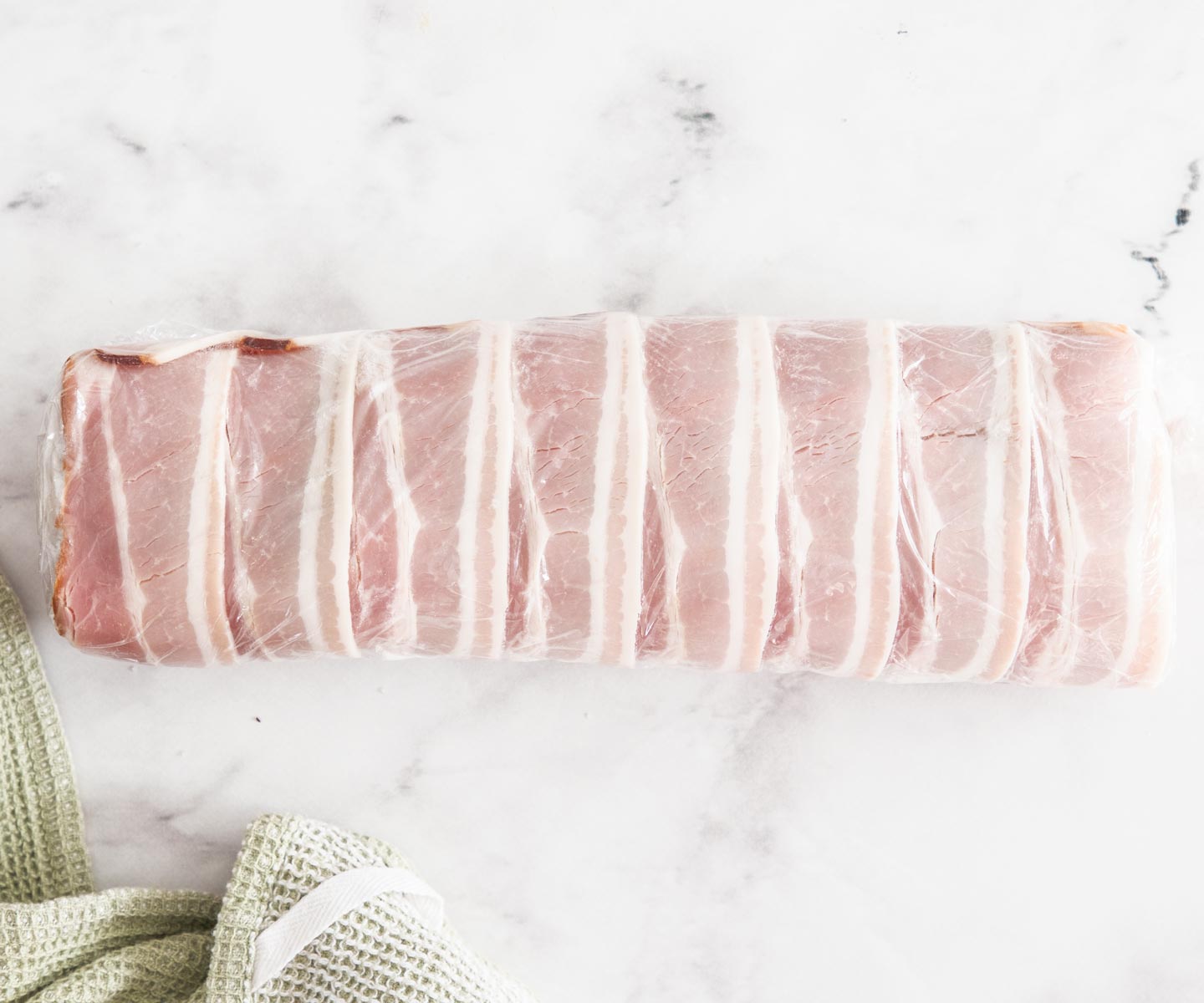 Bacon-wrapped Beef Tenderloin Bacon-wrapped beef tenderloin wrapped in plastic wrapped.