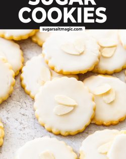 A pile of almond cookies topped with icing and flaked almonds.