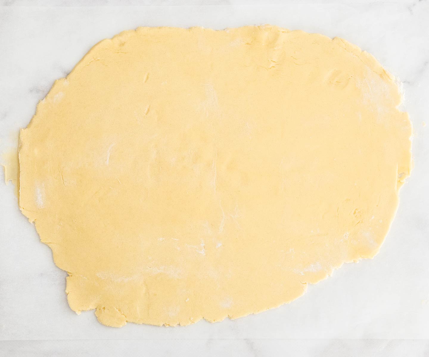 The dough rolled out on a marble surface.