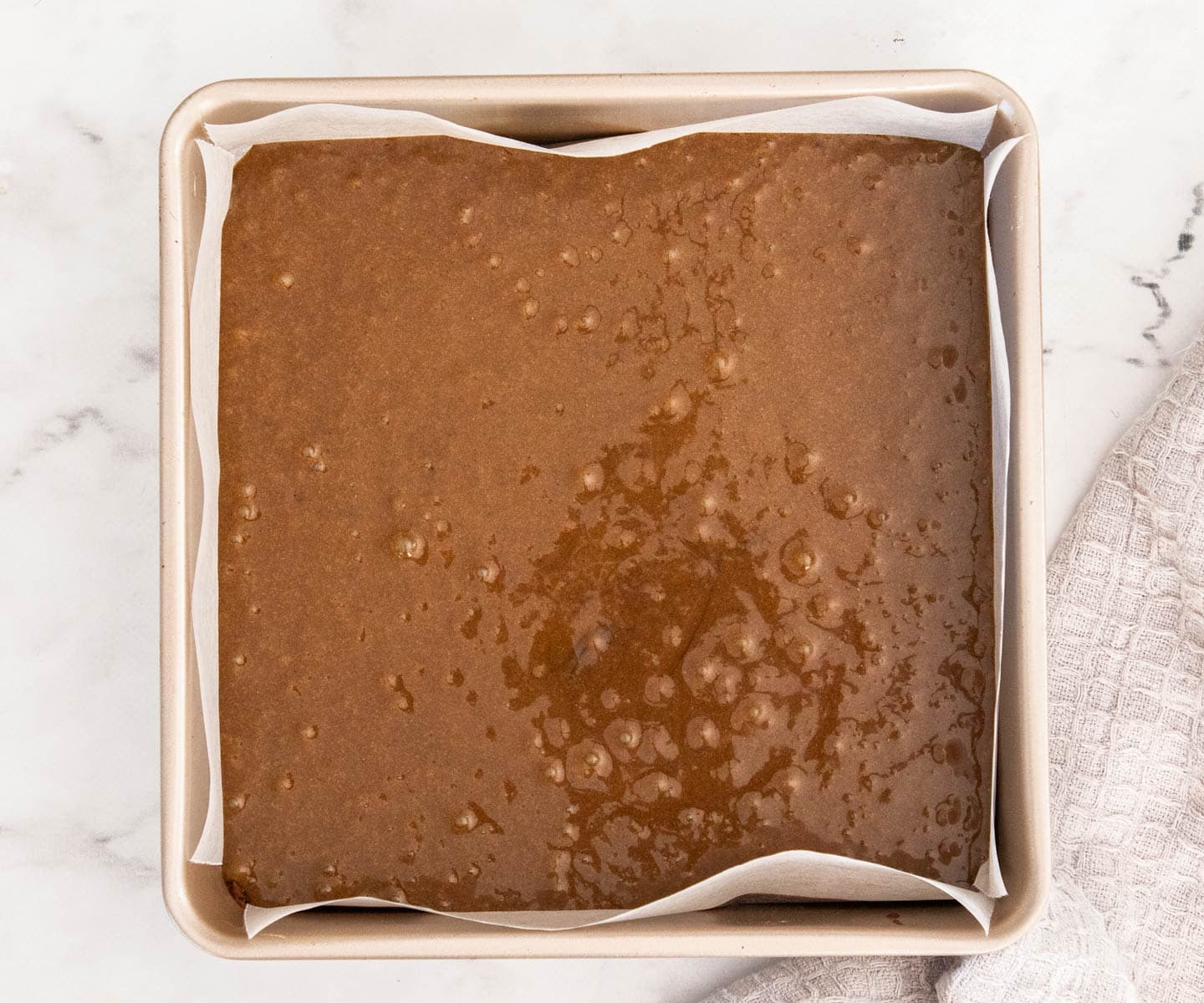 The gingerbread blondie batter in a square baking pan.