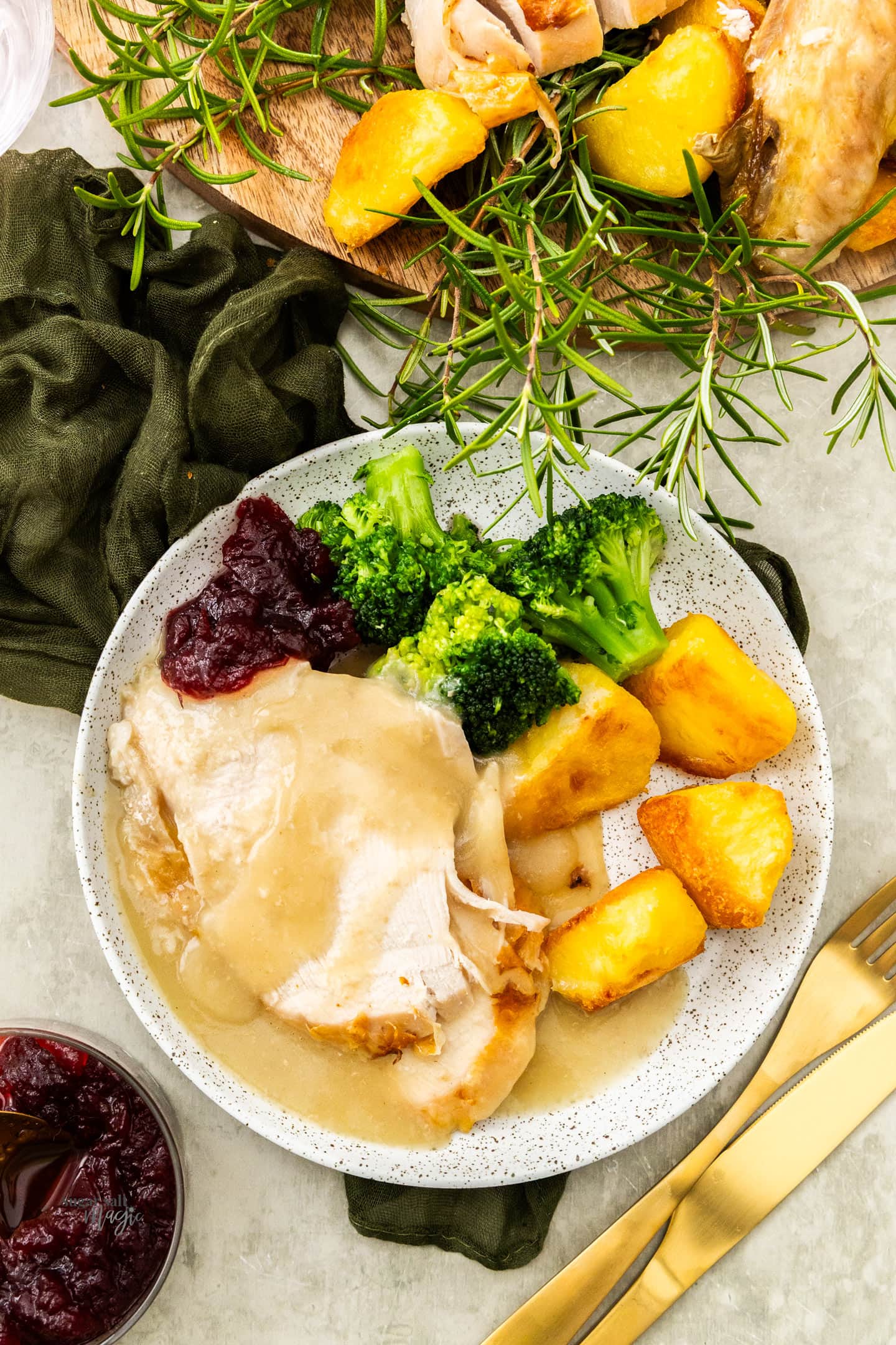 Top down view of roast turkey, potatoes and broccoli on a plate.