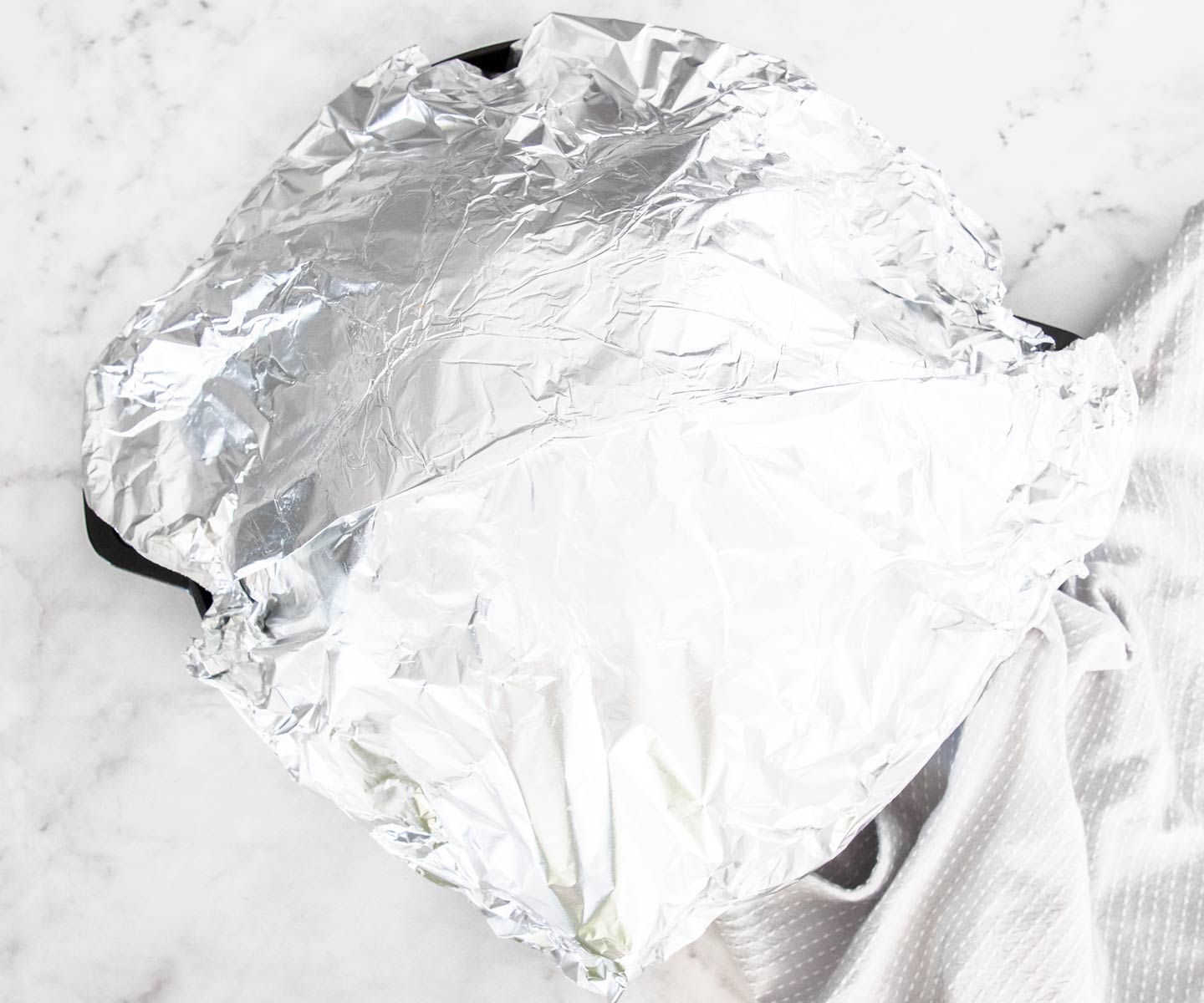 The turkey covered in foil ready for roasting.