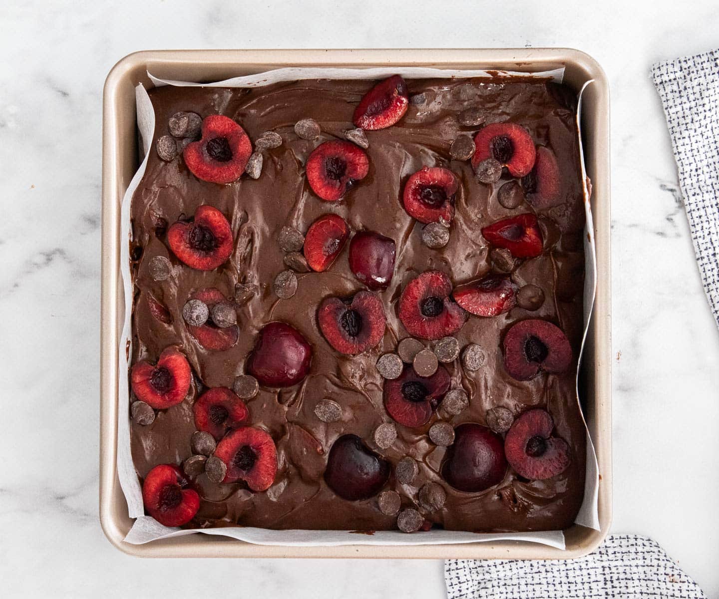 Cherry Crumble The cherry brownie batter in a baking pan topped with cherries.