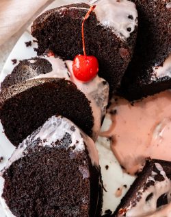 Top down view of a bundt cake cut into slices topped with icing.