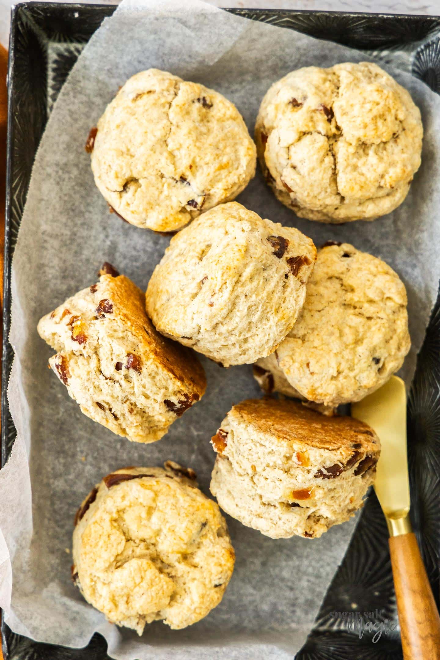 Date Scones Top down view of 7 date scones in a metal tray.