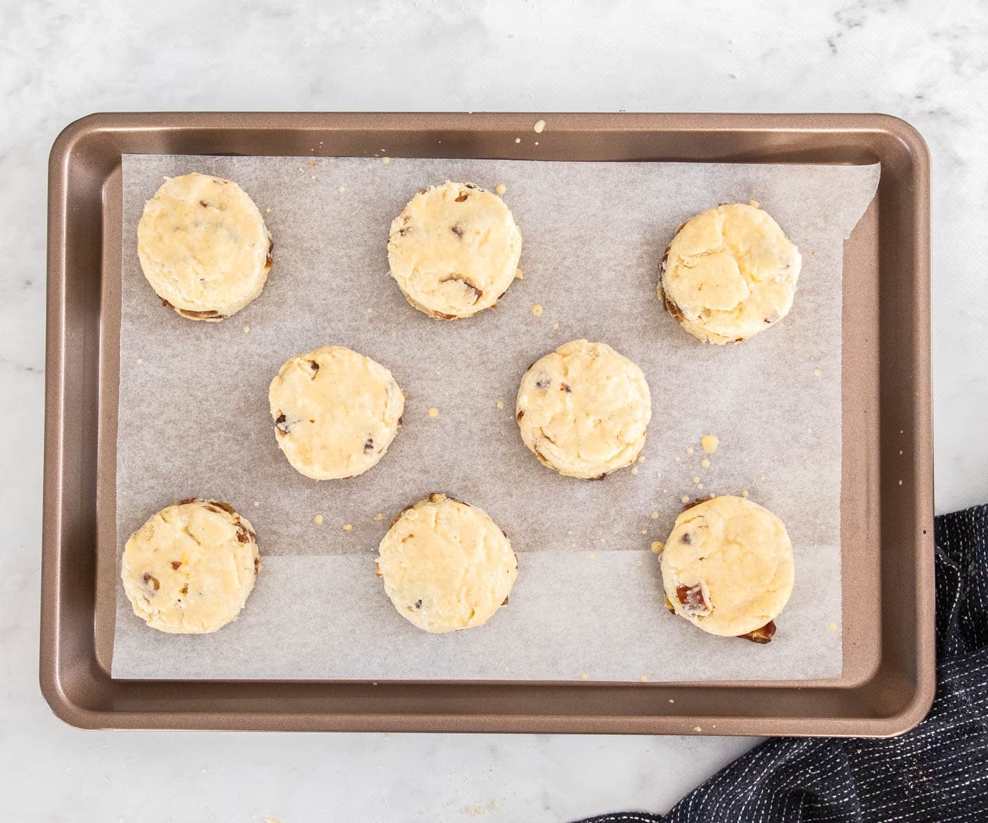 Date Scones Top down view of a tray of date scones before baking.