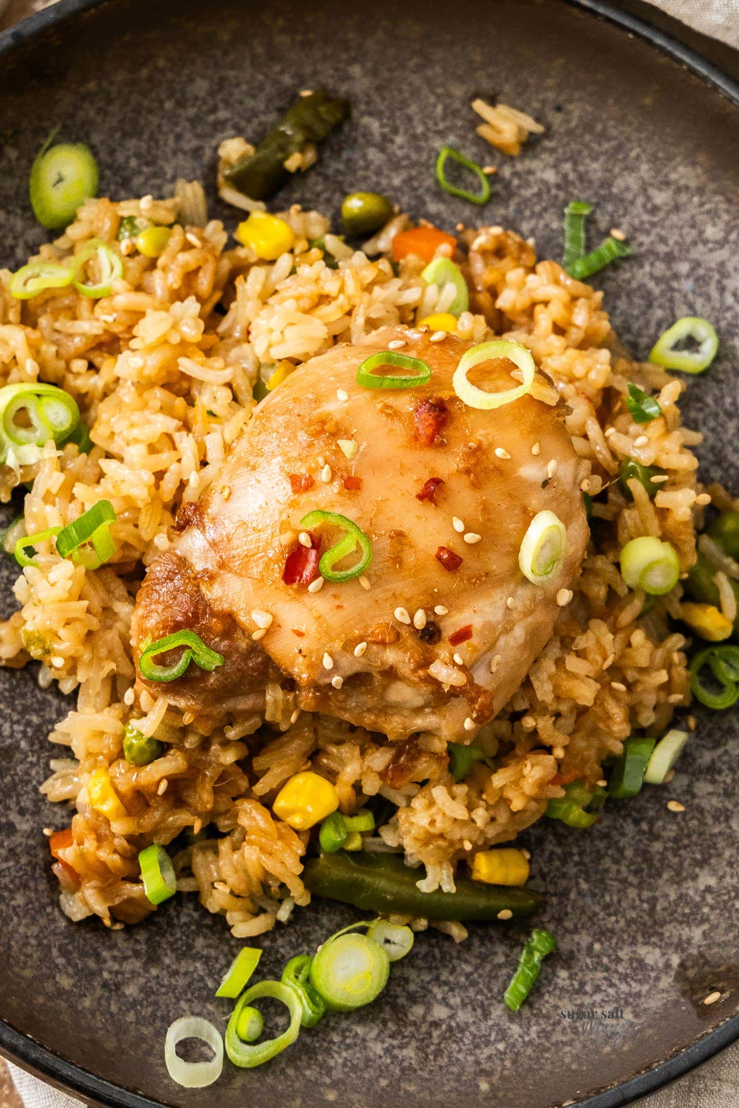 One Pan Baked Chicken and Rice Top down view of the one pan chicken and rice bake on a dinner plate.