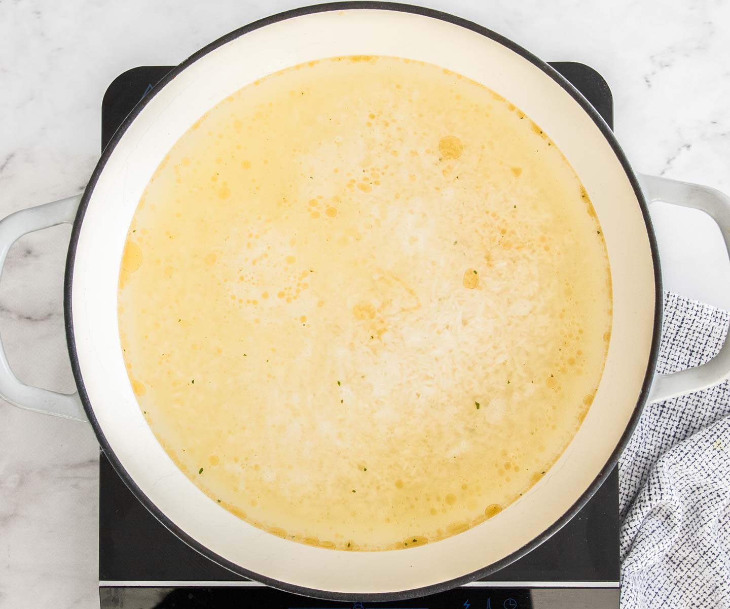 One Pan Baked Chicken and Rice The stock simmering in the pan.