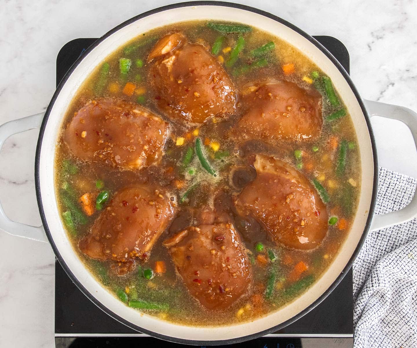 One Pan Baked Chicken and Rice The raw chicken thighs nestled into the rice and stock.