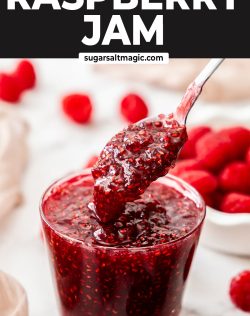 A spoon taking raspberry jam from a glass.