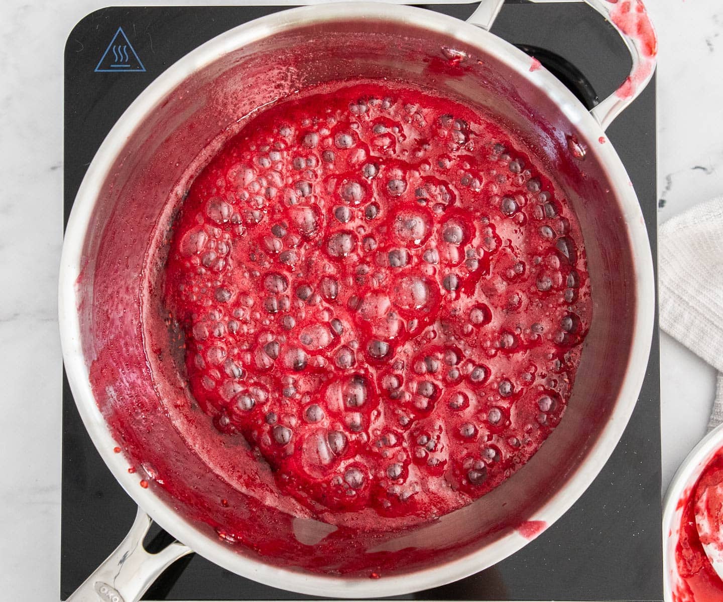 Easy Raspberry Jam The jam bubbling away in a saucepan.