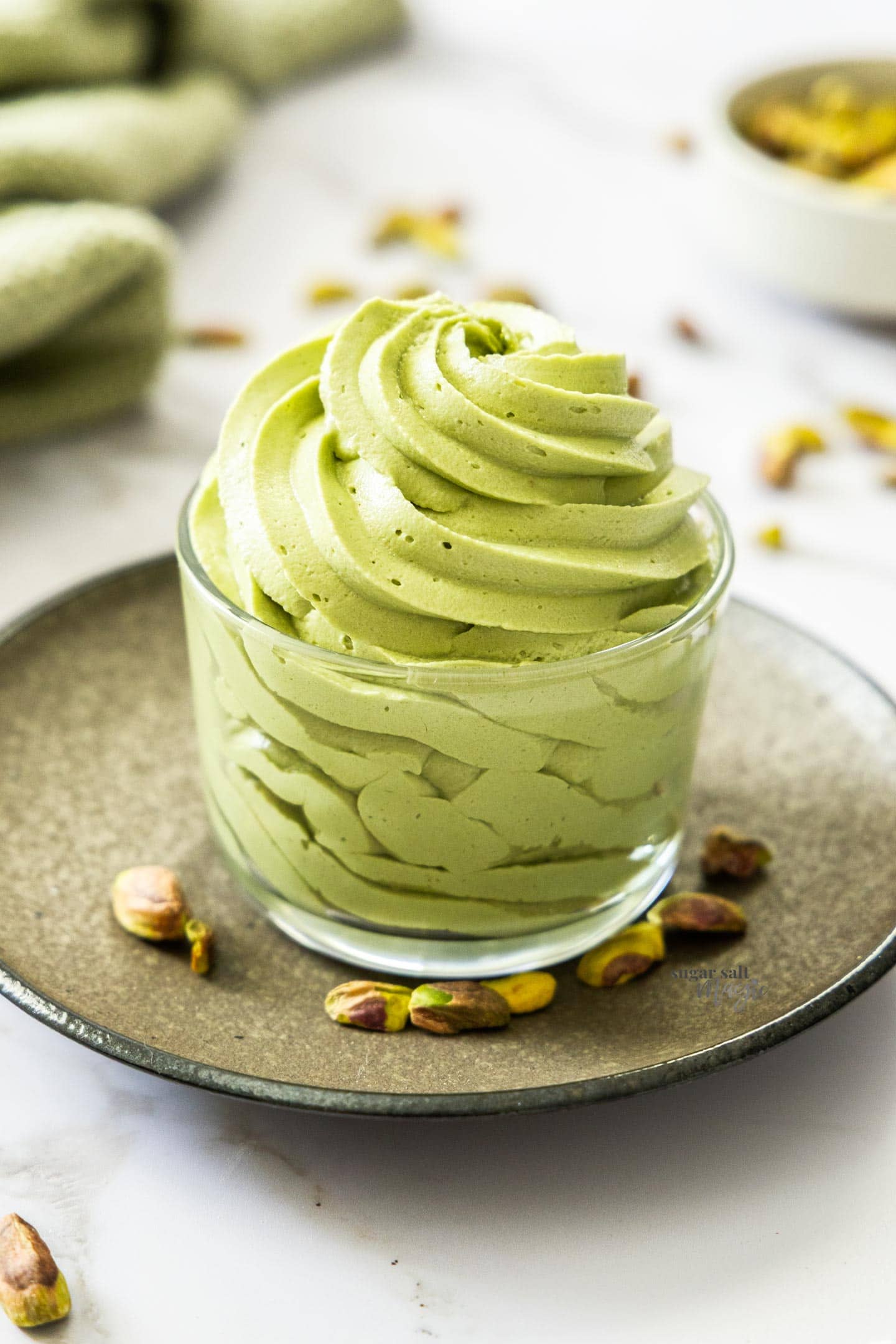 Pistachio Buttercream A swirl of pistachio buttercream filling a glass.