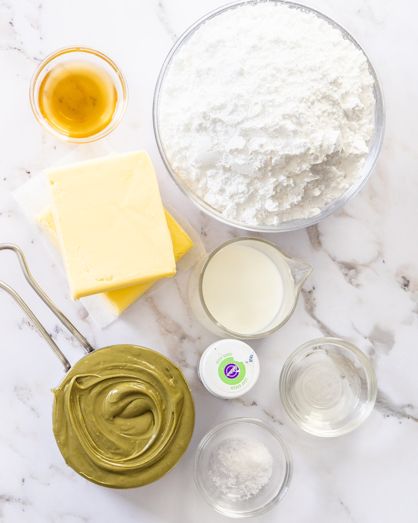 Pistachio Buttercream Ingredients for pistachio buttercream on a marble surface.