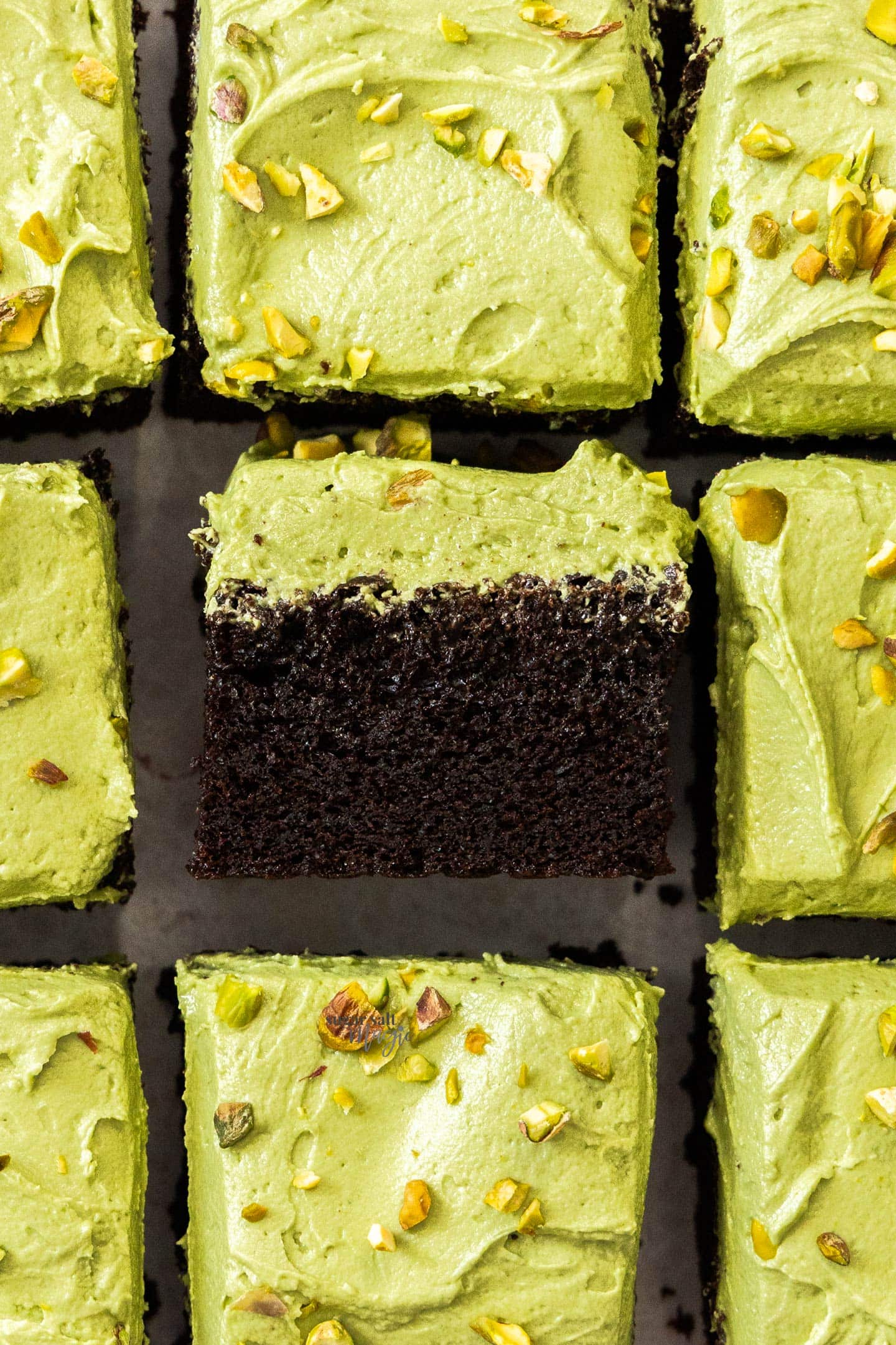 Pistachio Chocolate Snack Cake Top down view of 9 squares of pistachio chocolate cake with the middle one turned on it's side.