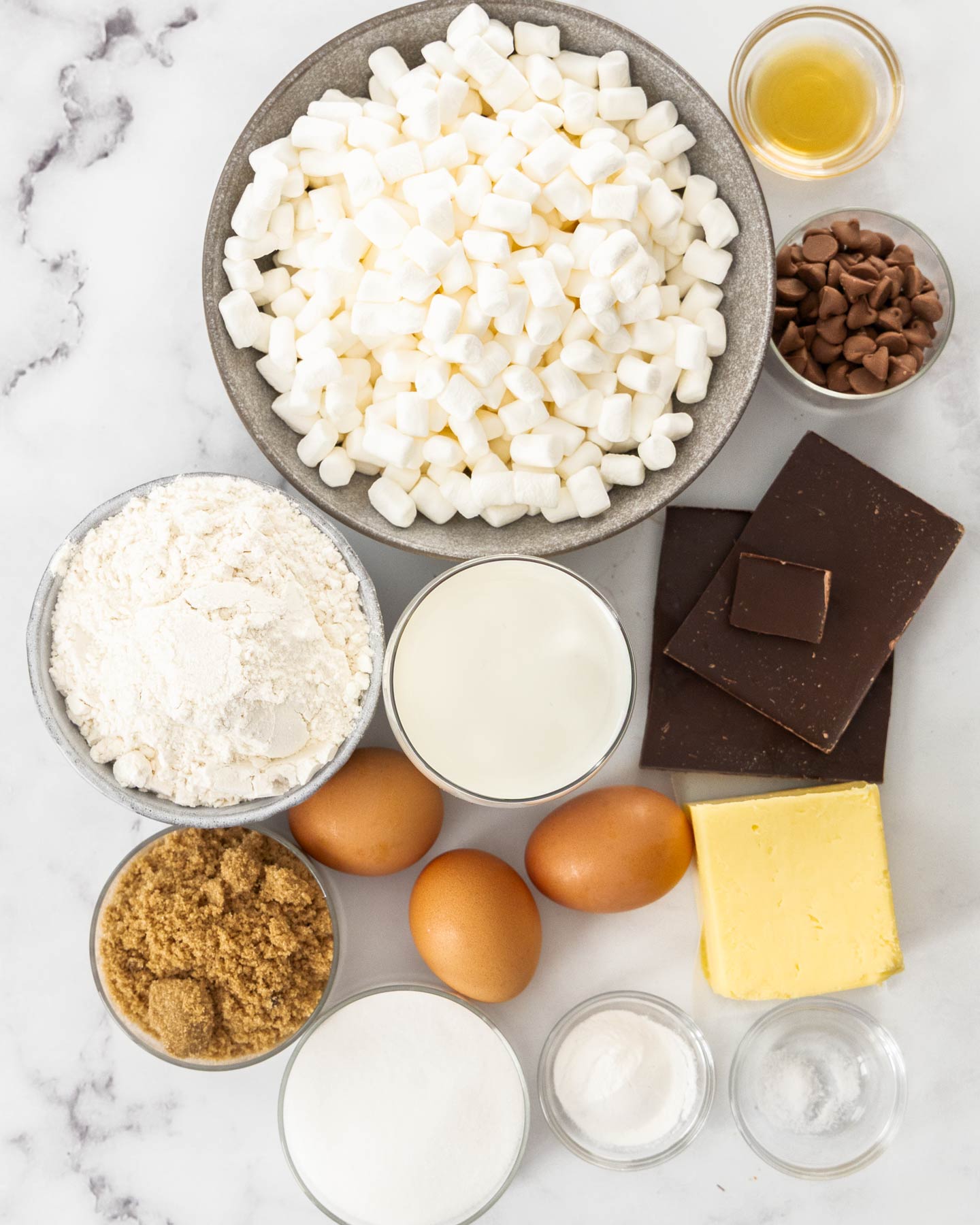 S'mores Cookie Bars Ingredients for s'mores cookie bars on a marble surface.