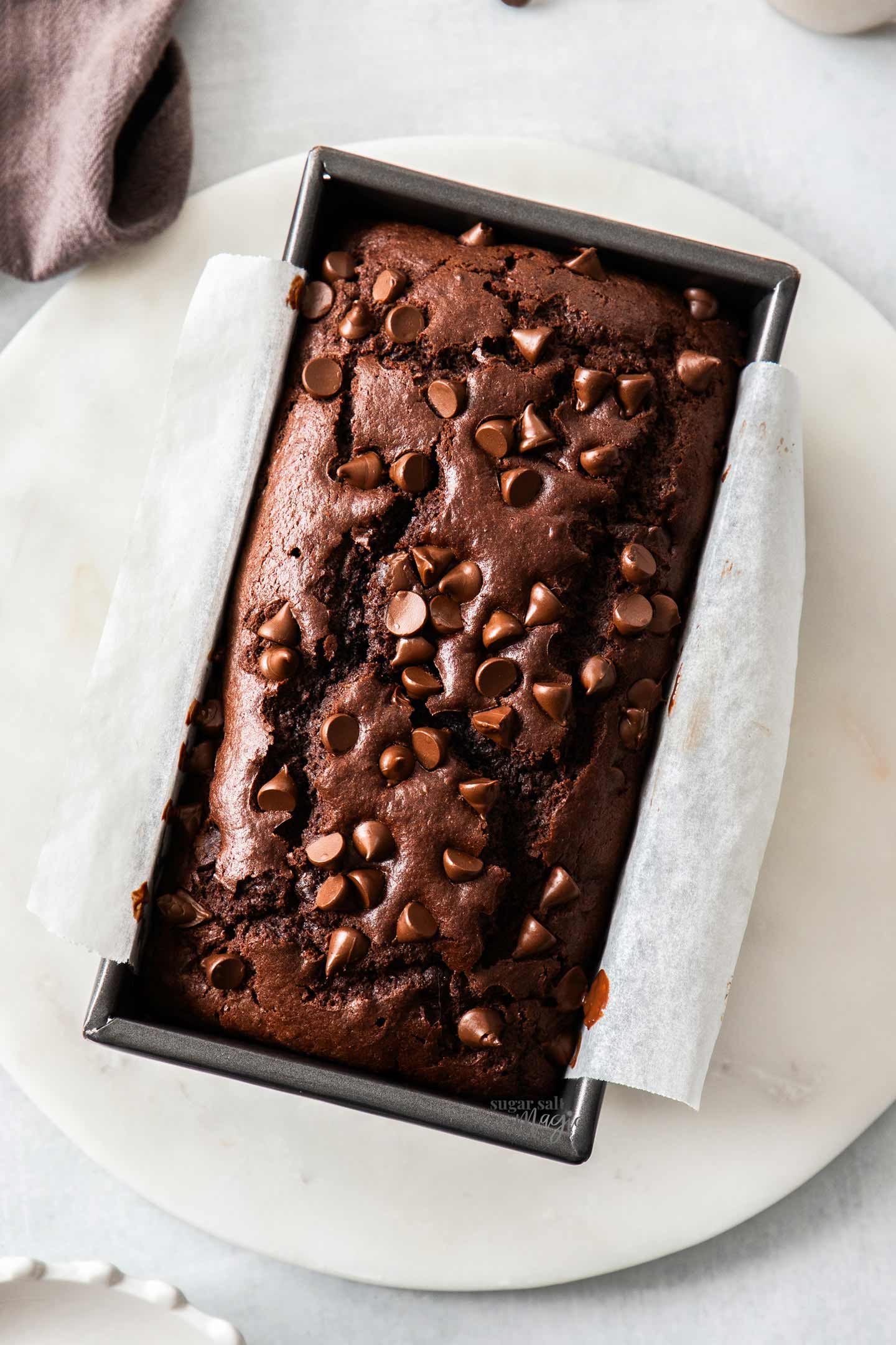 Quick Chocolate Bread (Chocolate Loaf Cake) Top down view of a chocolate loaf cake in a loaf pan.