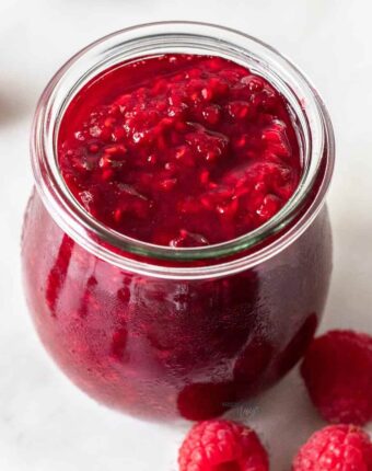 Closeup of a jar of raspberry compote.