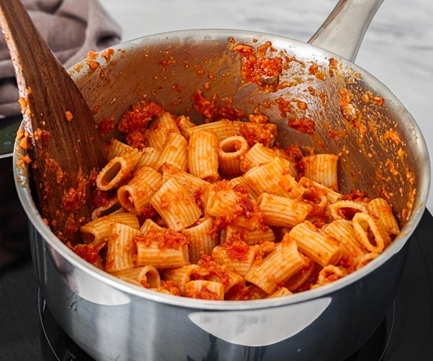 Sun-dried Tomato Pesto Pasta Pasta in a saucepan, mixed with sundried tomato pesto.